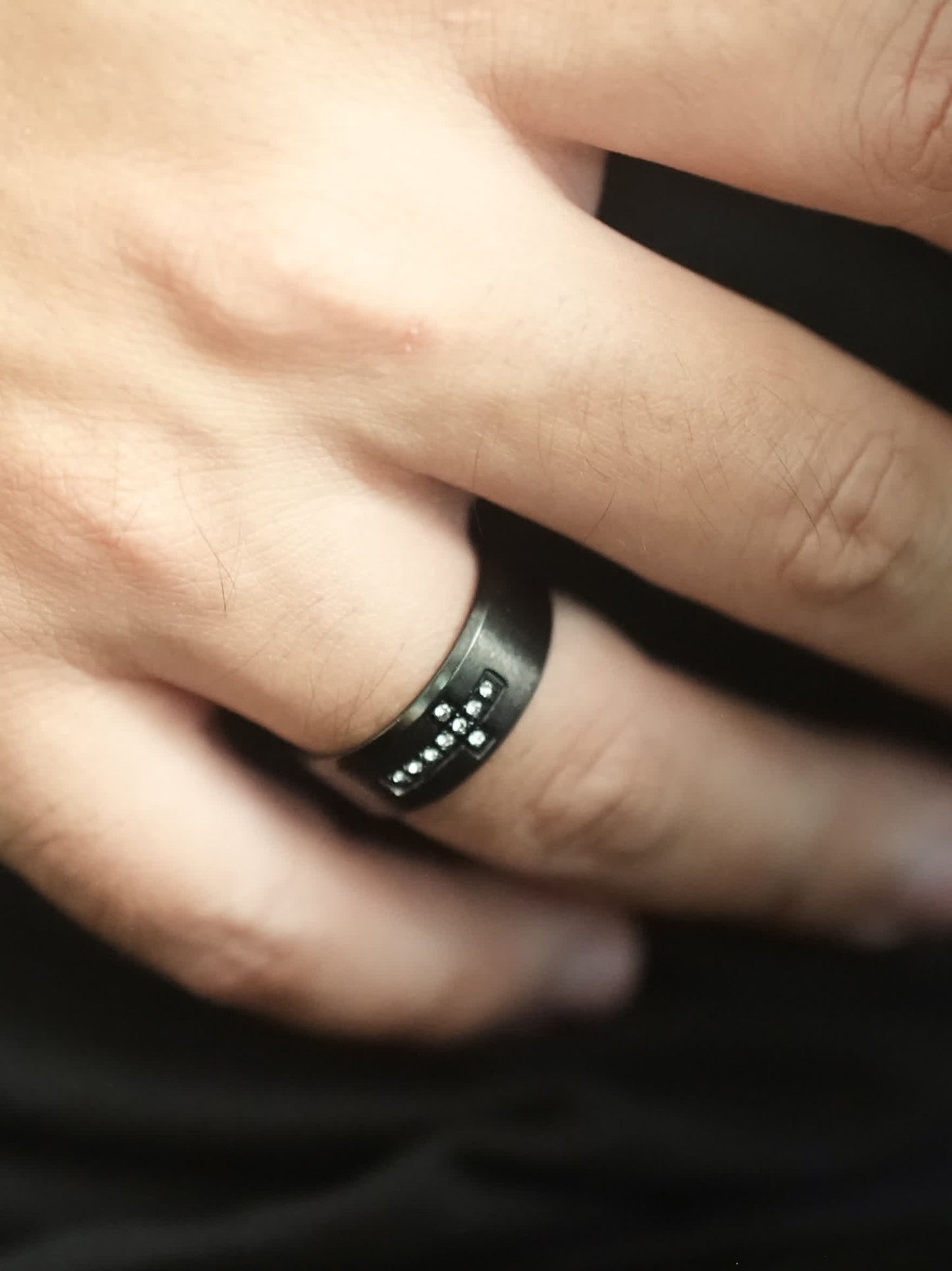 Man wearing the Creed Noir Black Cross Ring, close-up of the hand showing how the ring fits and reflects light in a lifestyle setting.
