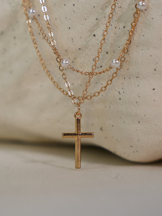 Three-layer Christian necklace featuring pearl accents and gold cross pendant