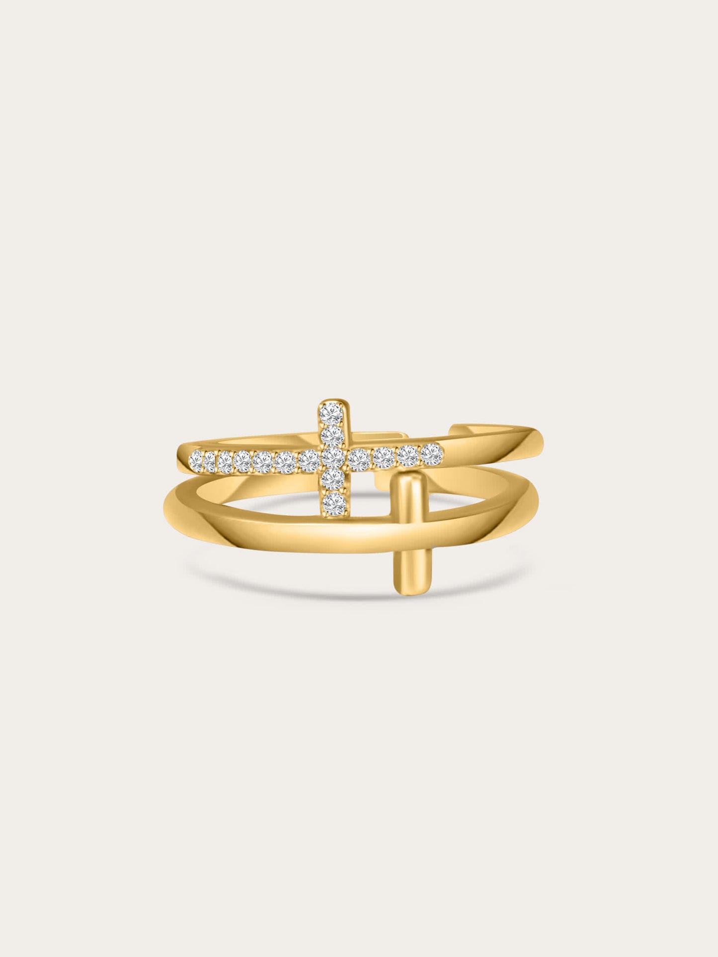 Front-facing studio photo of the Faith Shield Double Cross Gold Ring with pavé zircon cross and smooth gold cross, set against a soft beige background