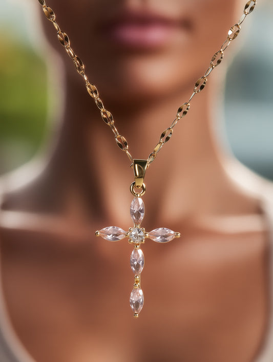 Feminine cross pendant worn on model, showing delicate gold chain and blush gemstone sparkle