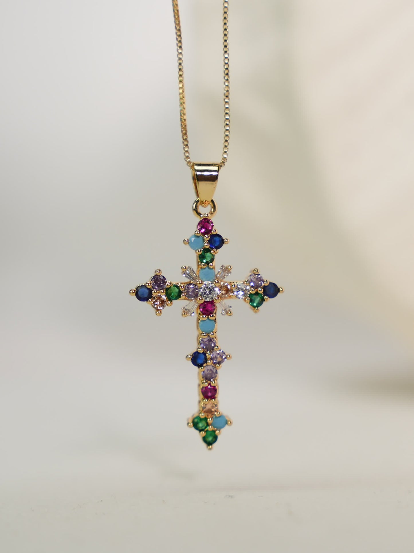 Pendant displayed upright on neutral background with soft lighting, highlighting gold setting and multicolor crystal arrangement