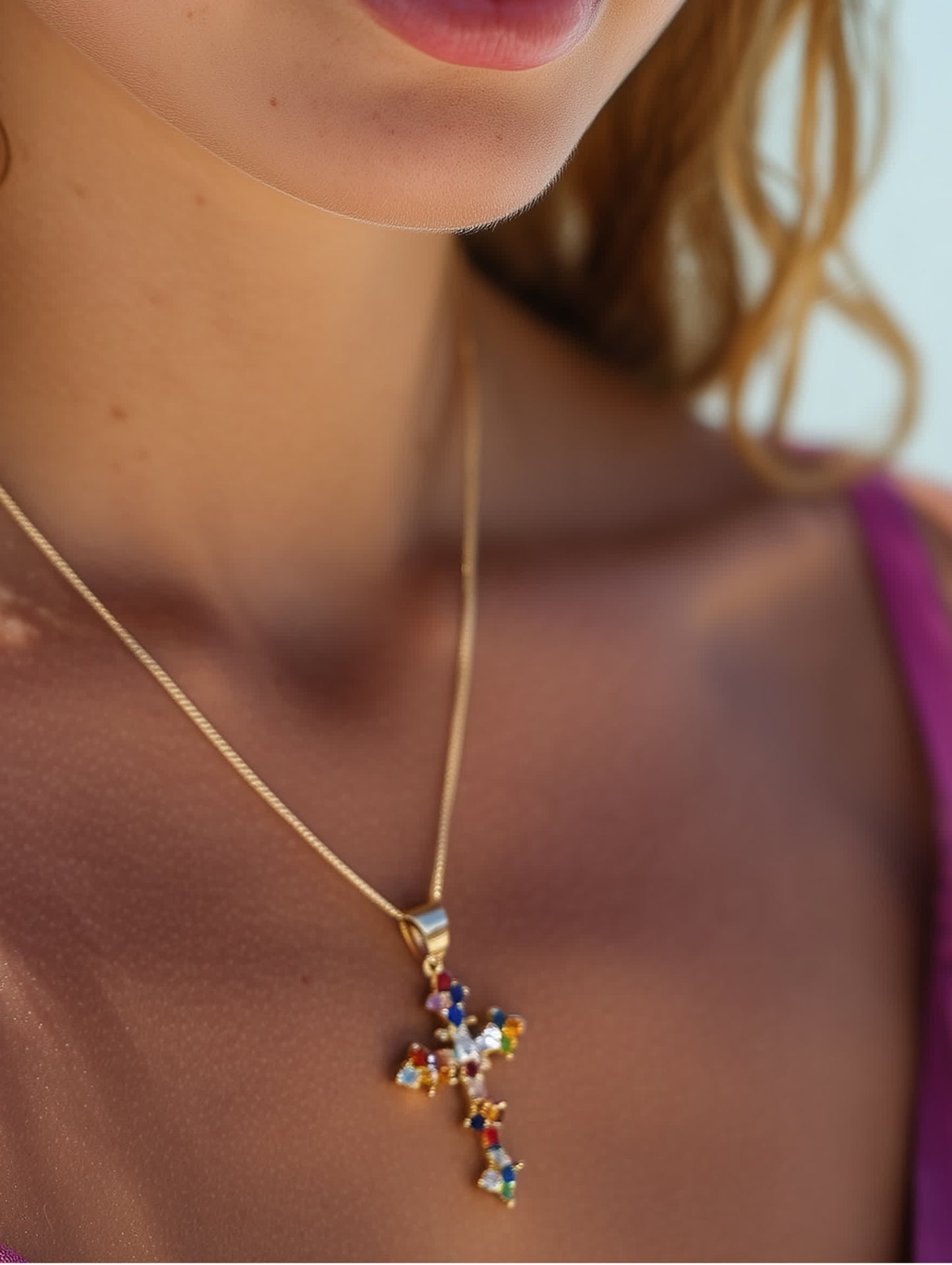 Model wearing necklace showing the colorful cross pendant against her neckline, demonstrating fit and radiant sparkle