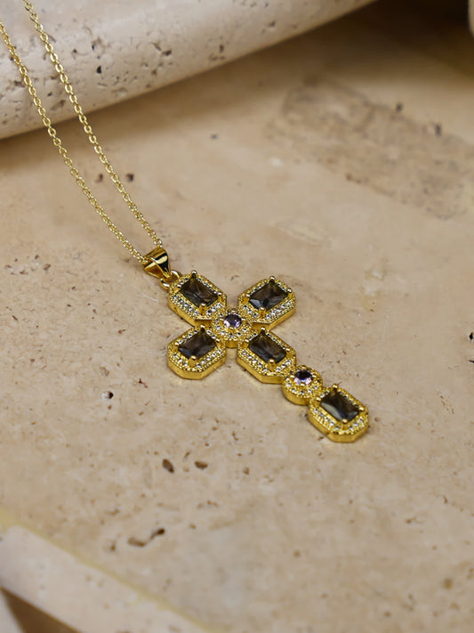 Gold vintage cross necklace laid flat on a natural stone backdrop with warm lighting, highlighting intricate pavé detail