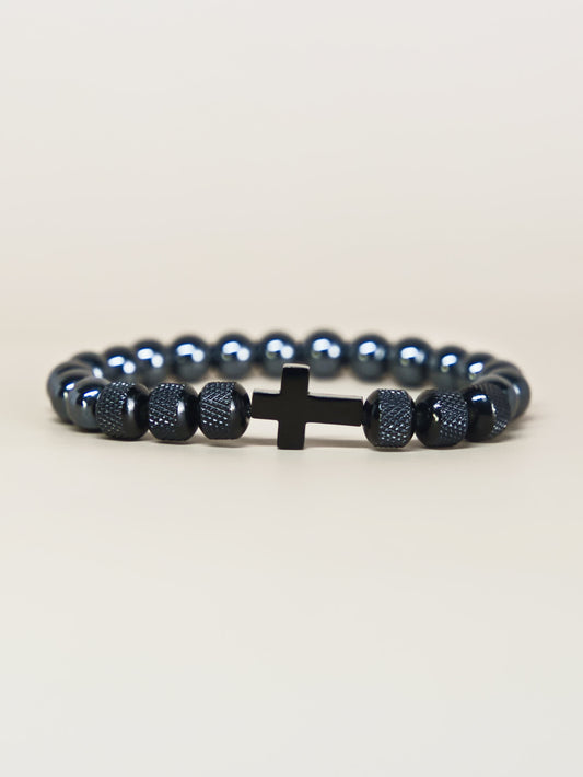 Front-facing angled photo of the Iron Grace Beaded Cross Bracelet highlighting the contrast between shiny beads and matte textured spacers, set on a neutral background.