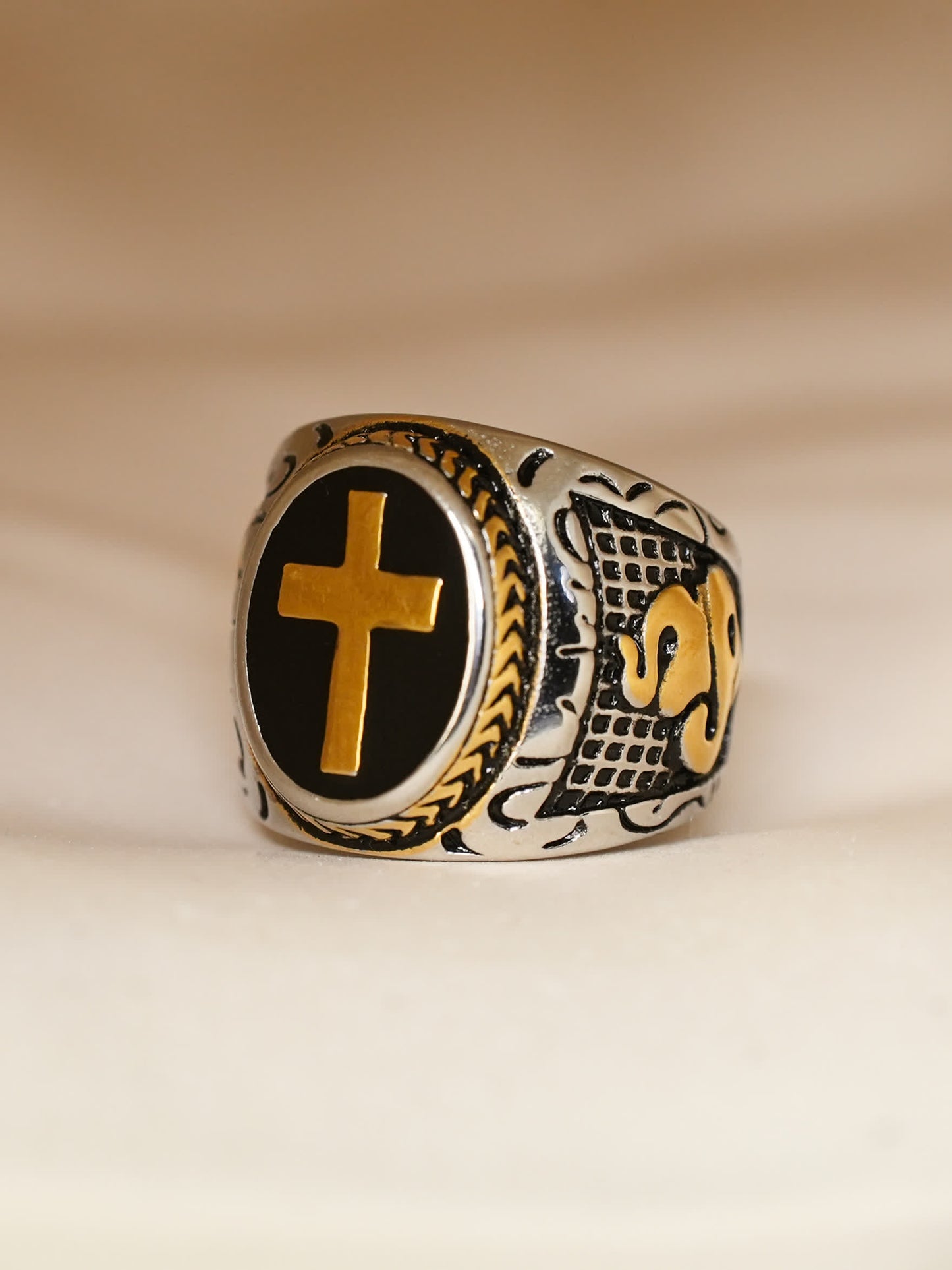 Close-up of the engraved side detail of the ring featuring rope and armor-style pattern in silver and gold