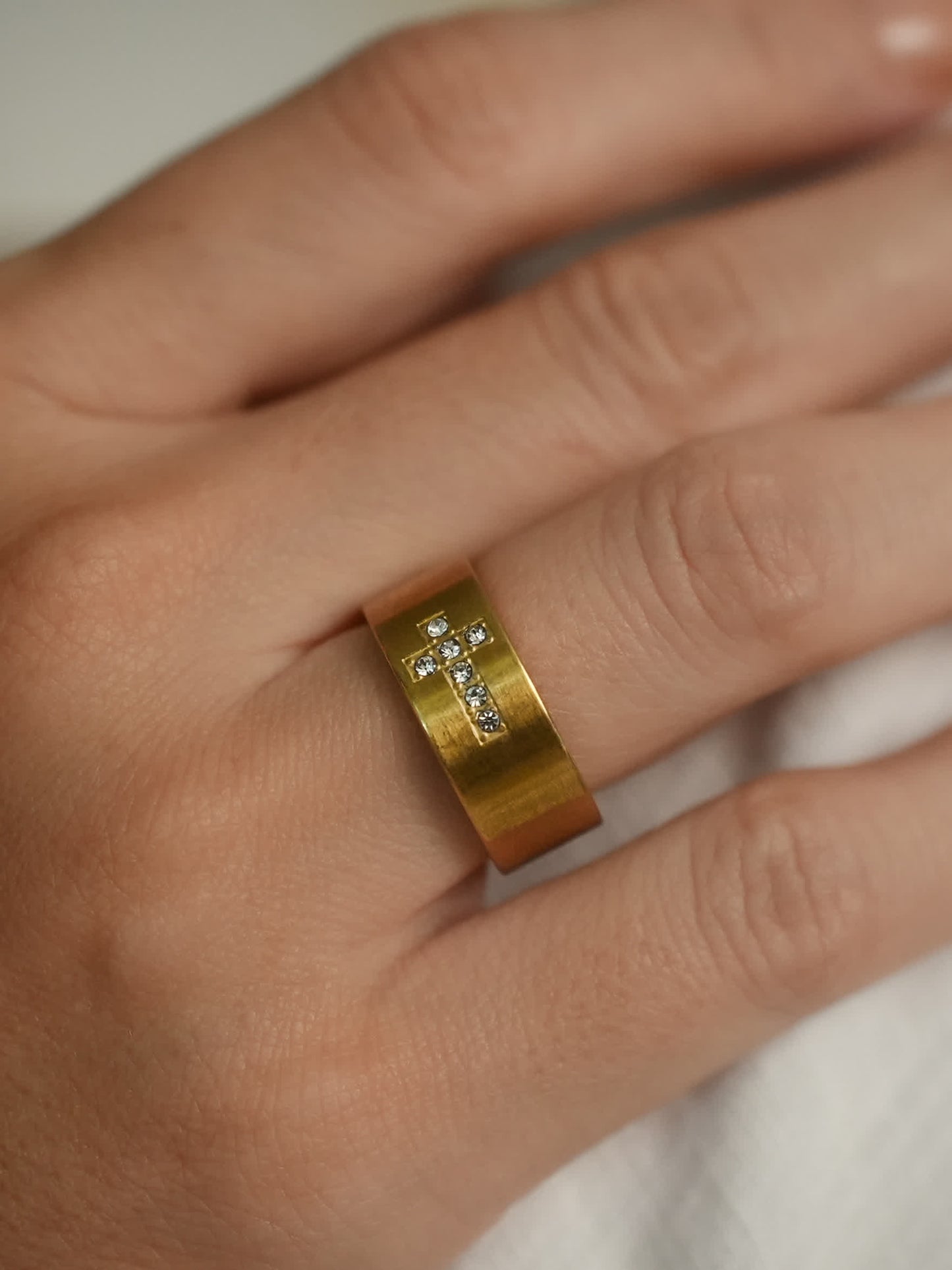 Close-up – Gold Ring on Hand
Women’s gold ring with sparkling cubic zirconia cross design, shown on hand in natural light