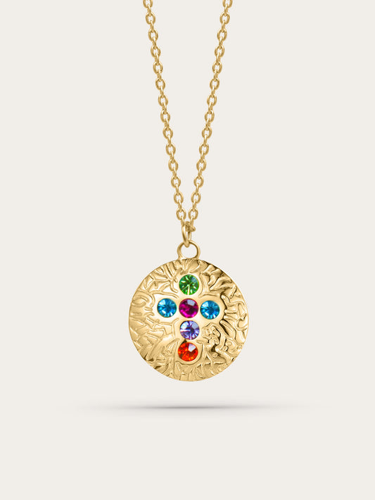 Gold medallion cross necklace with multicolor zircon stones on neutral background