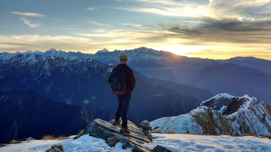 Person standing on a mountain at sunrise, reflecting courage and trust
