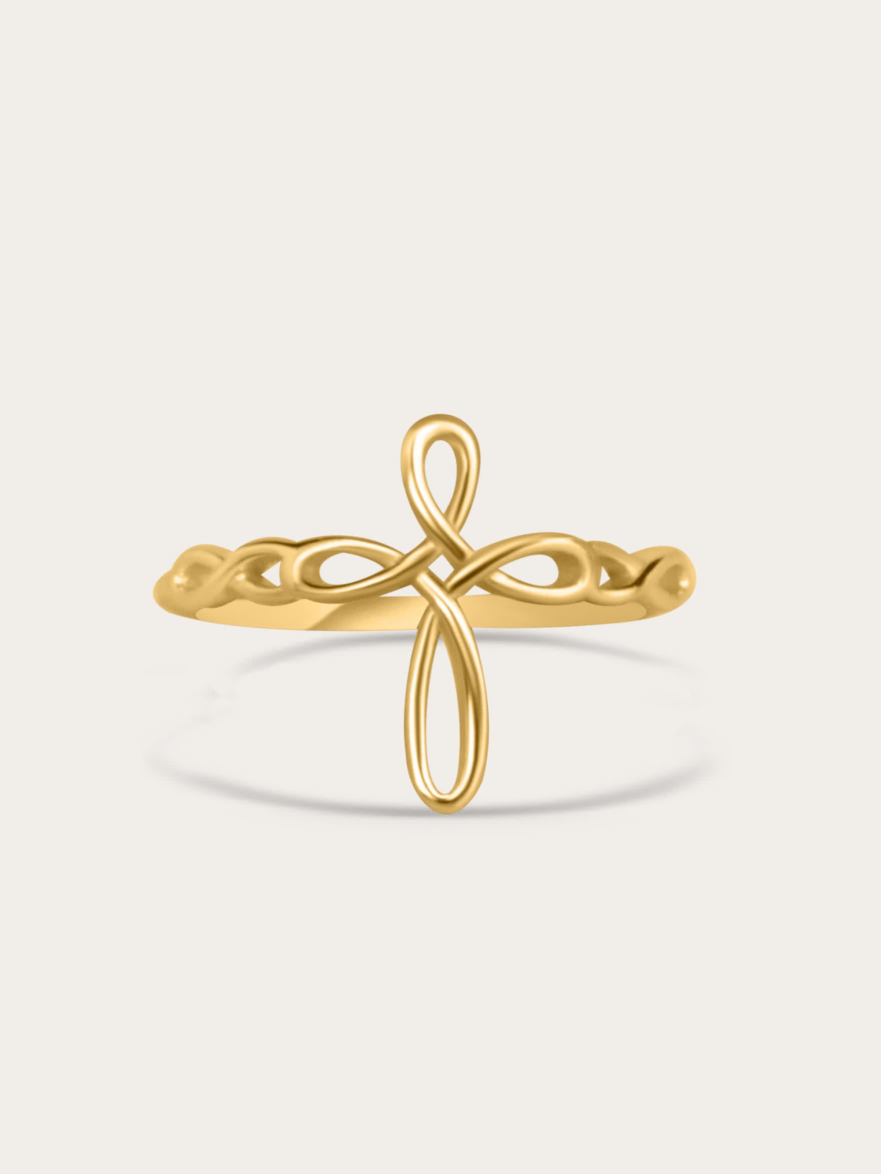 Front-facing studio image of sculptural ribbon-style faith ring in 18K gold plating, centered on light beige background