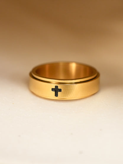 Close-up of gold-plated Christian spinner ring, black engraved cross clearly visible