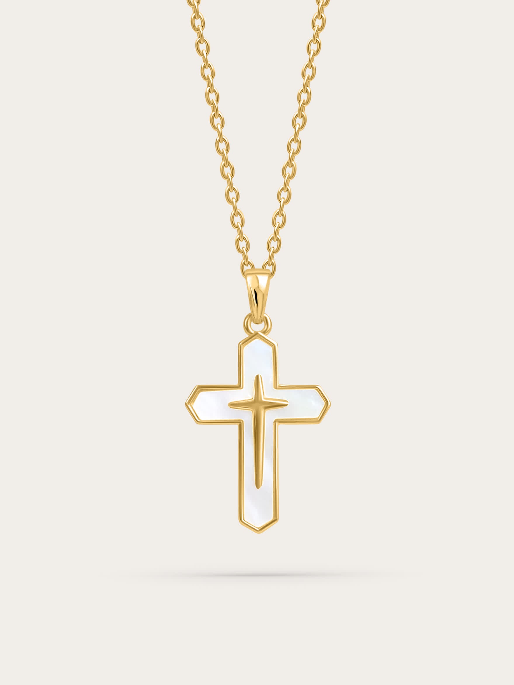 Front-facing product image of a gold cross necklace with white enamel inlay on a light background

