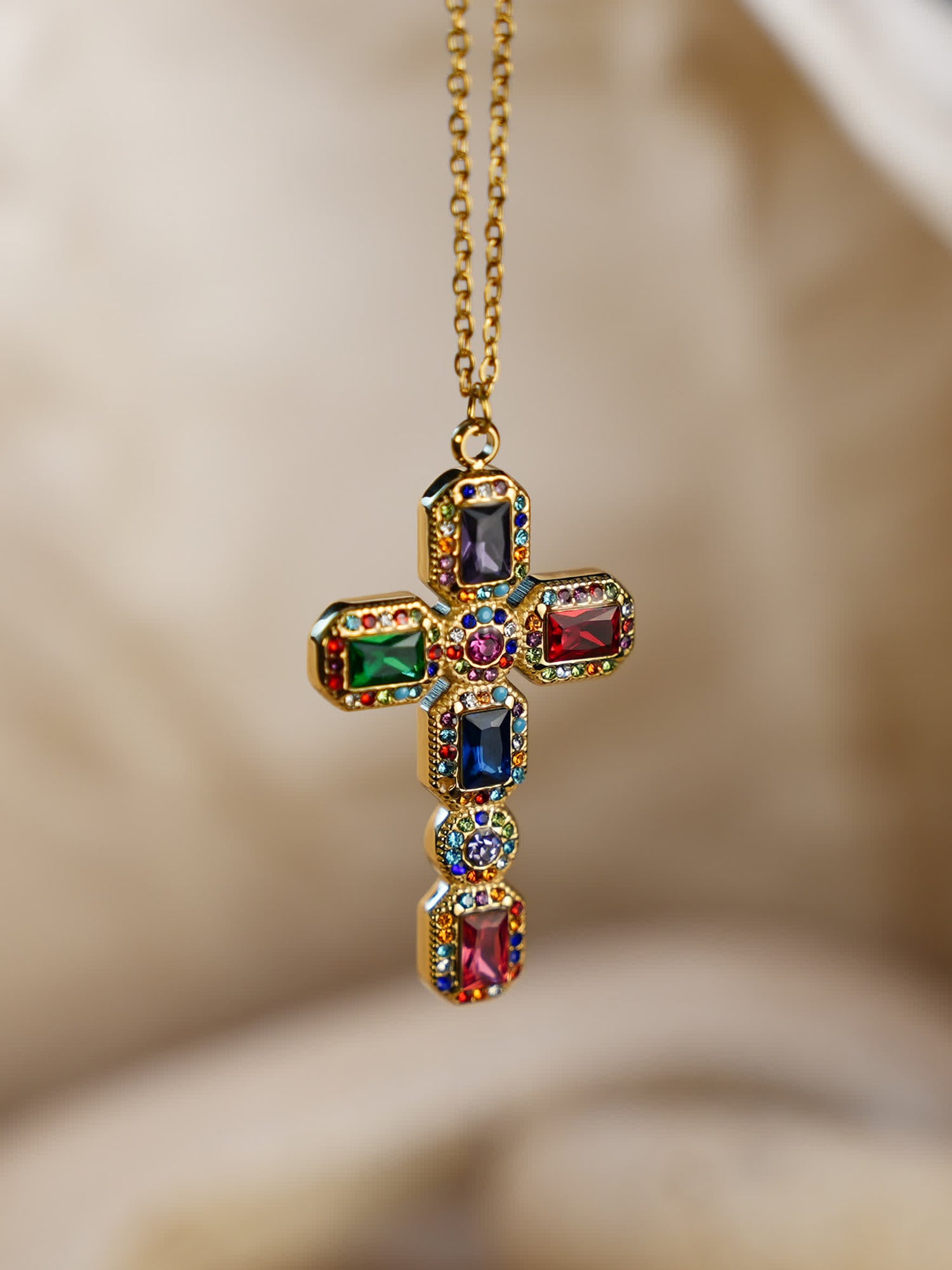 Front-facing close-up of the Baroque multicolor gemstone cross necklace hanging against a soft neutral background, showcasing vivid zircon inlays and ornate gold setting.