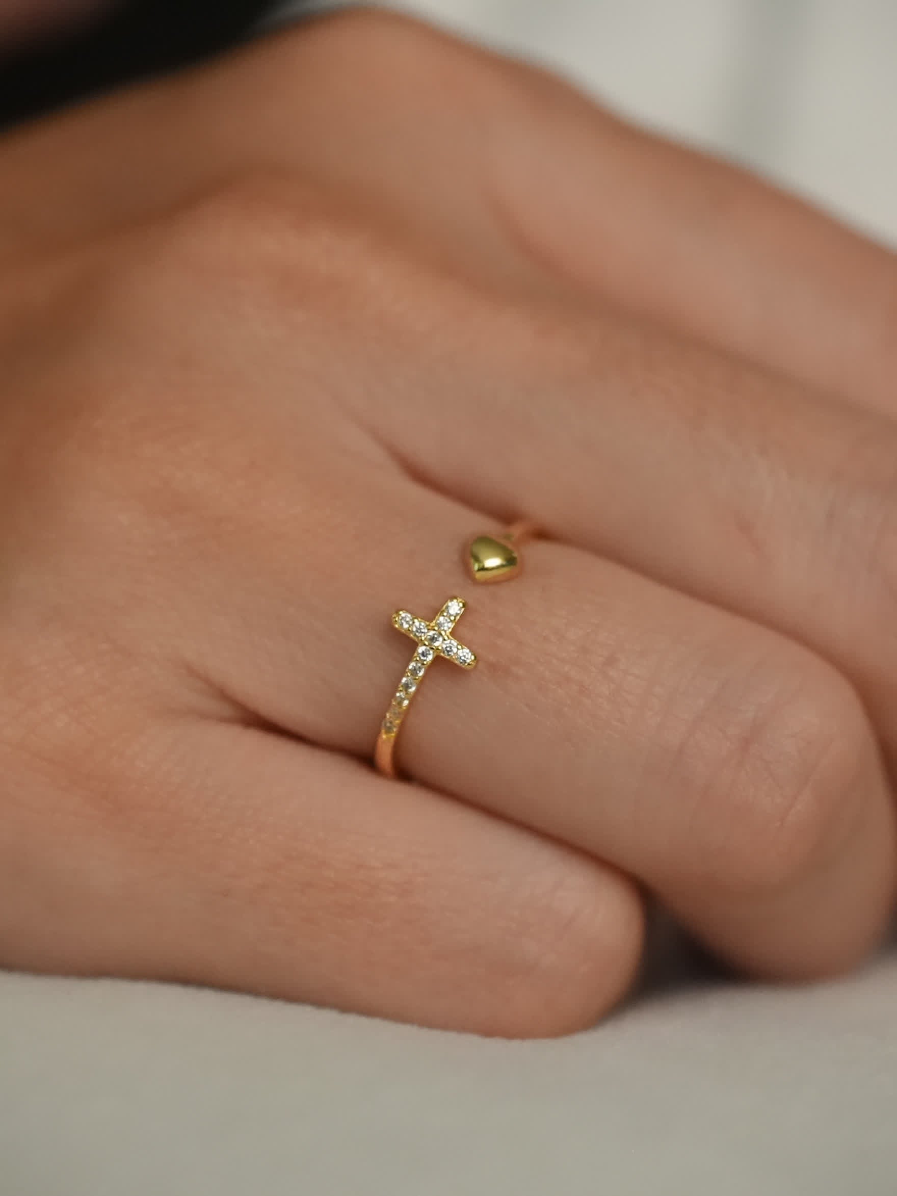 Gold faith ring with pavé cross and heart accent shown on woman’s hand
