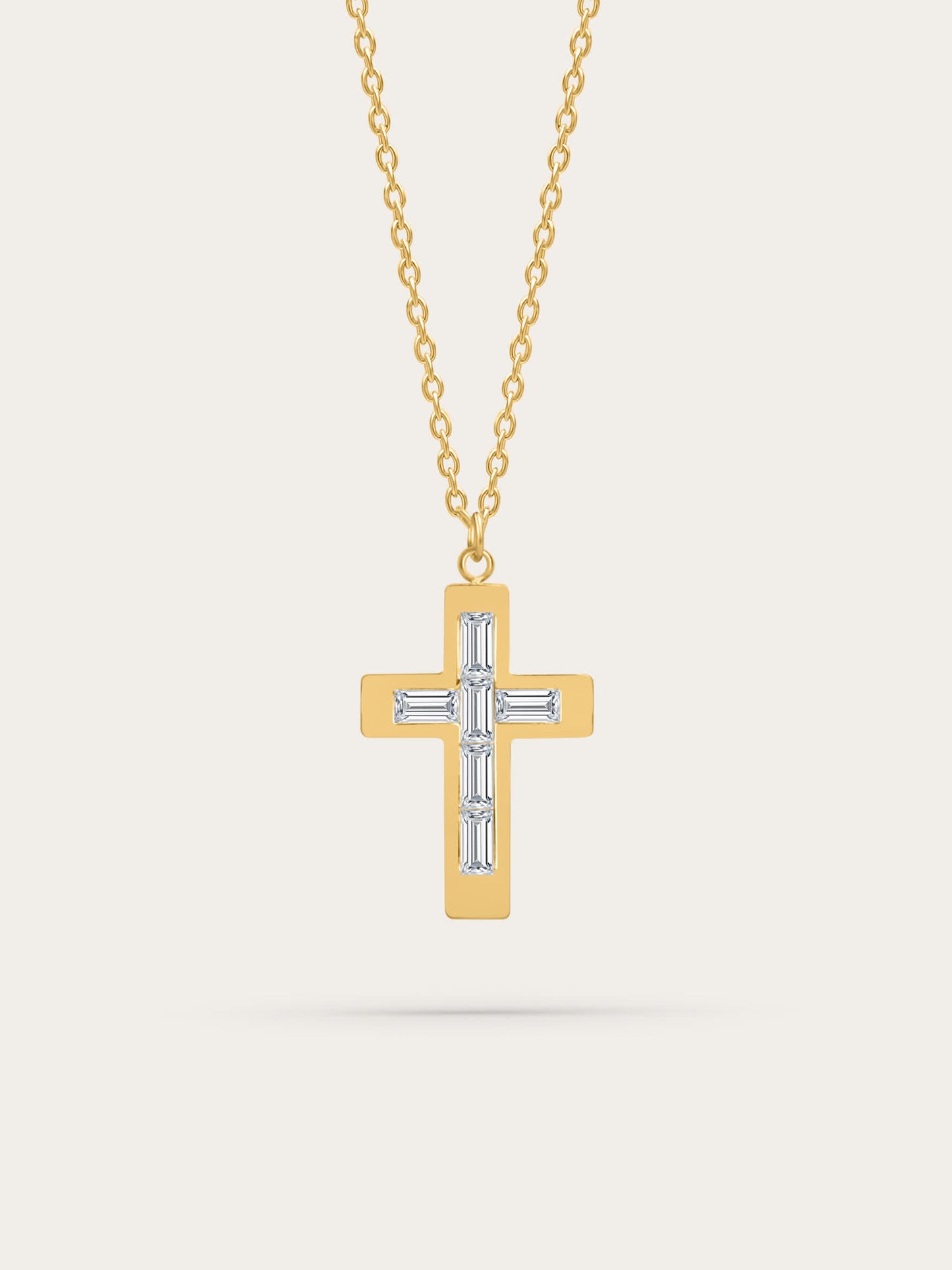 Gold cross necklace with baguette-cut zircon stones on neutral background