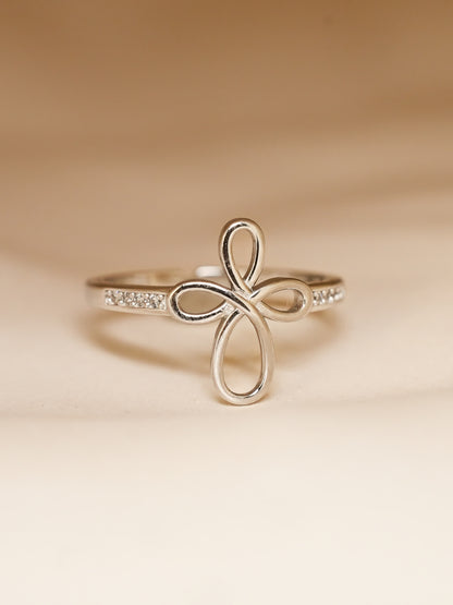 Covenant Bloom Ring worn on hand, highlighting the delicate silver heart cross shape and sparkling band in natural lighting