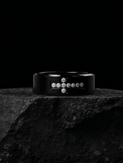 Creed Noir Black Cross Ring on black stone slab, dramatic lighting highlighting the contrast between the black surface and white crystals.