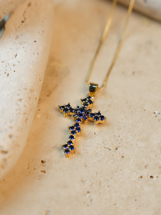 dark blue cross pendant on travertine
