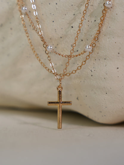 Three-layer Christian necklace featuring pearl accents and gold cross pendant