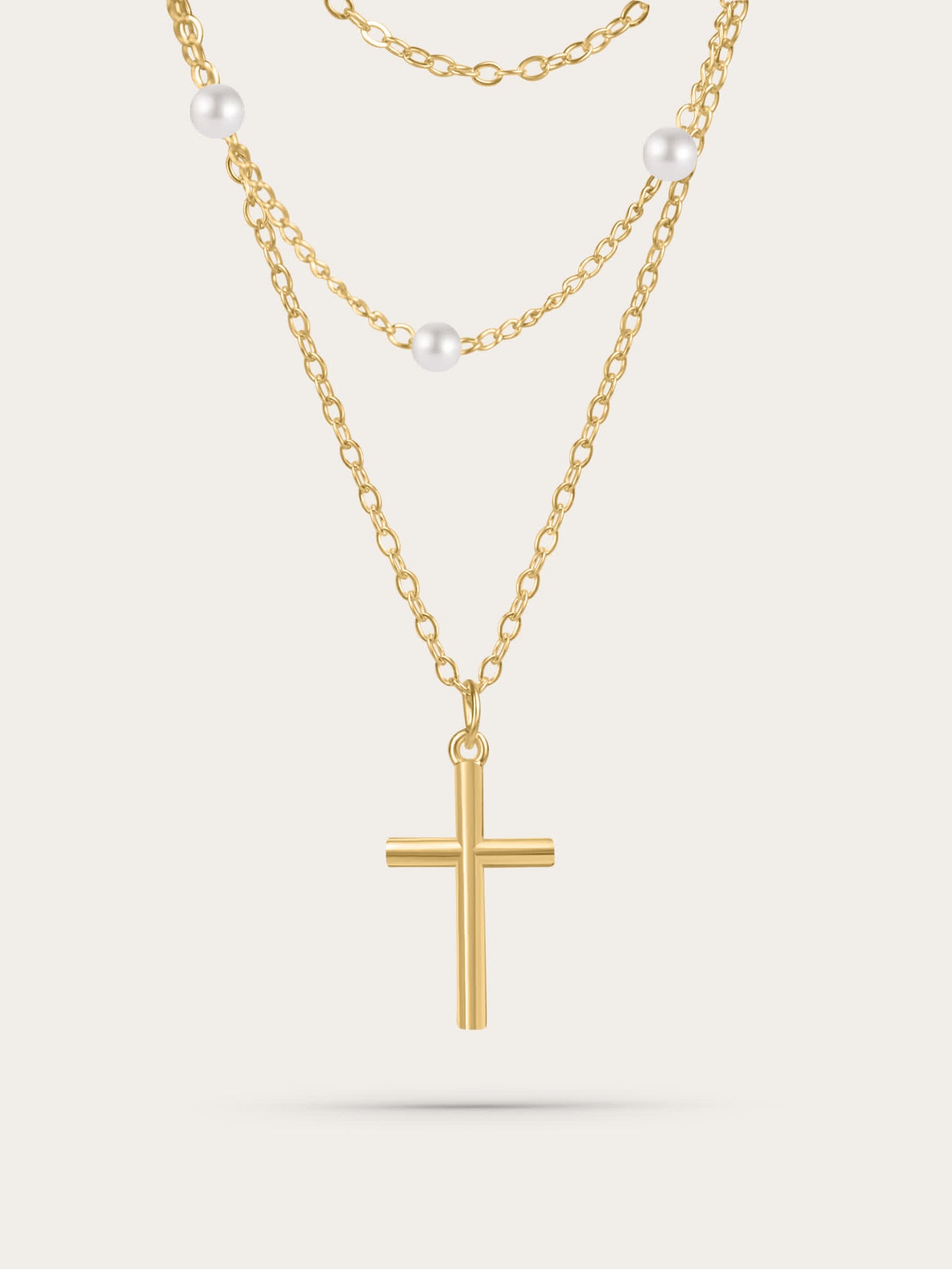 Gold layered cross necklace with freshwater pearls on white background