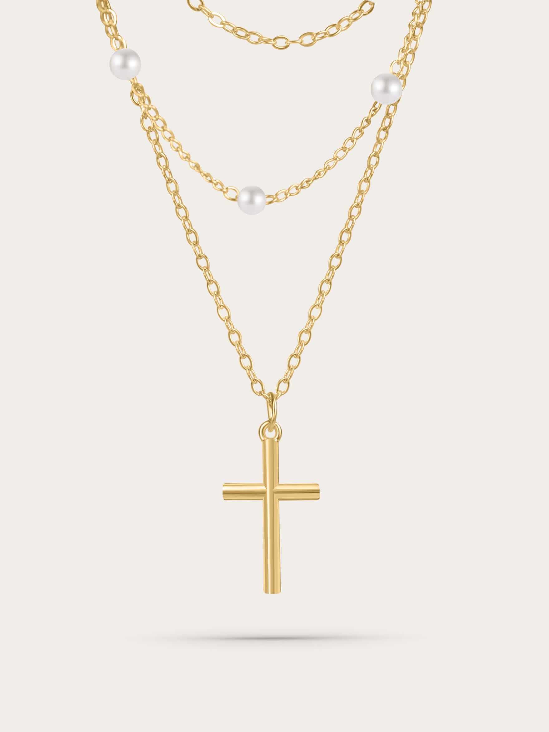 Gold layered cross necklace with freshwater pearls on white background