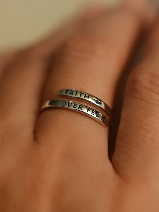Faith over fear wrap ring on hand, showing adjustable sterling silver band with Christian message