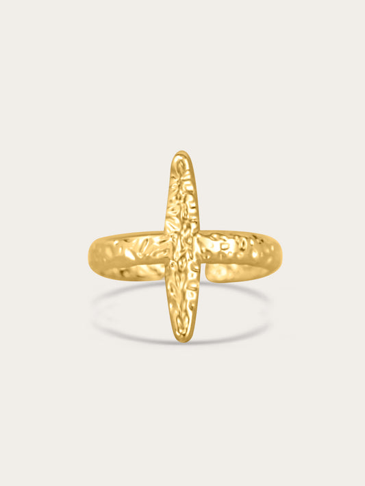 Front view of gold hammered open cross ring on neutral background