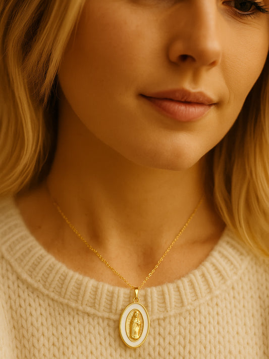 Model wearing the Madonna pendant necklace with the oval medal resting gently on the chest, styled with a soft cream knit top and subtle lighting.