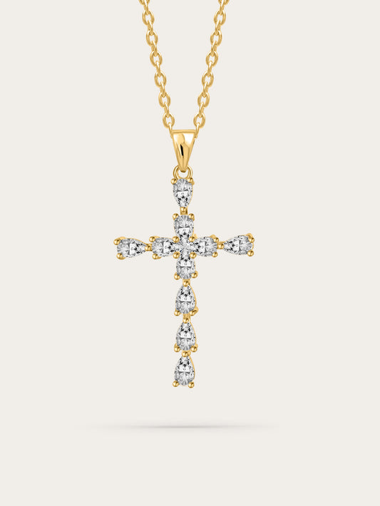 Studio shot of elegant gold cross necklace with teardrop zircon crystals on soft beige background
