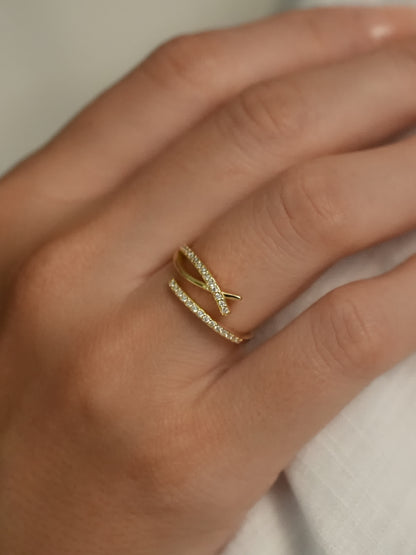 Ichthys-inspired gold cross ring worn on hand, showcasing its elegant wrap design and crystal sparkle