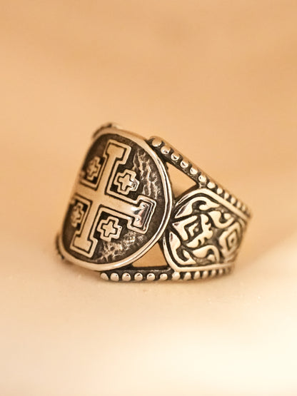 Side profile of the titanium steel ring against warm lighting, showcasing intricate etching and beaded edge