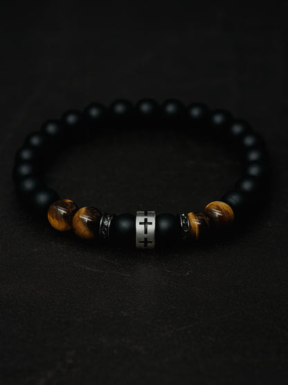 Moody overhead photo of the Lion's Peace Men's Religious Bracelet on a dark textured background, highlighting the contrast between the matte obsidian and the gleaming tiger’s eye.