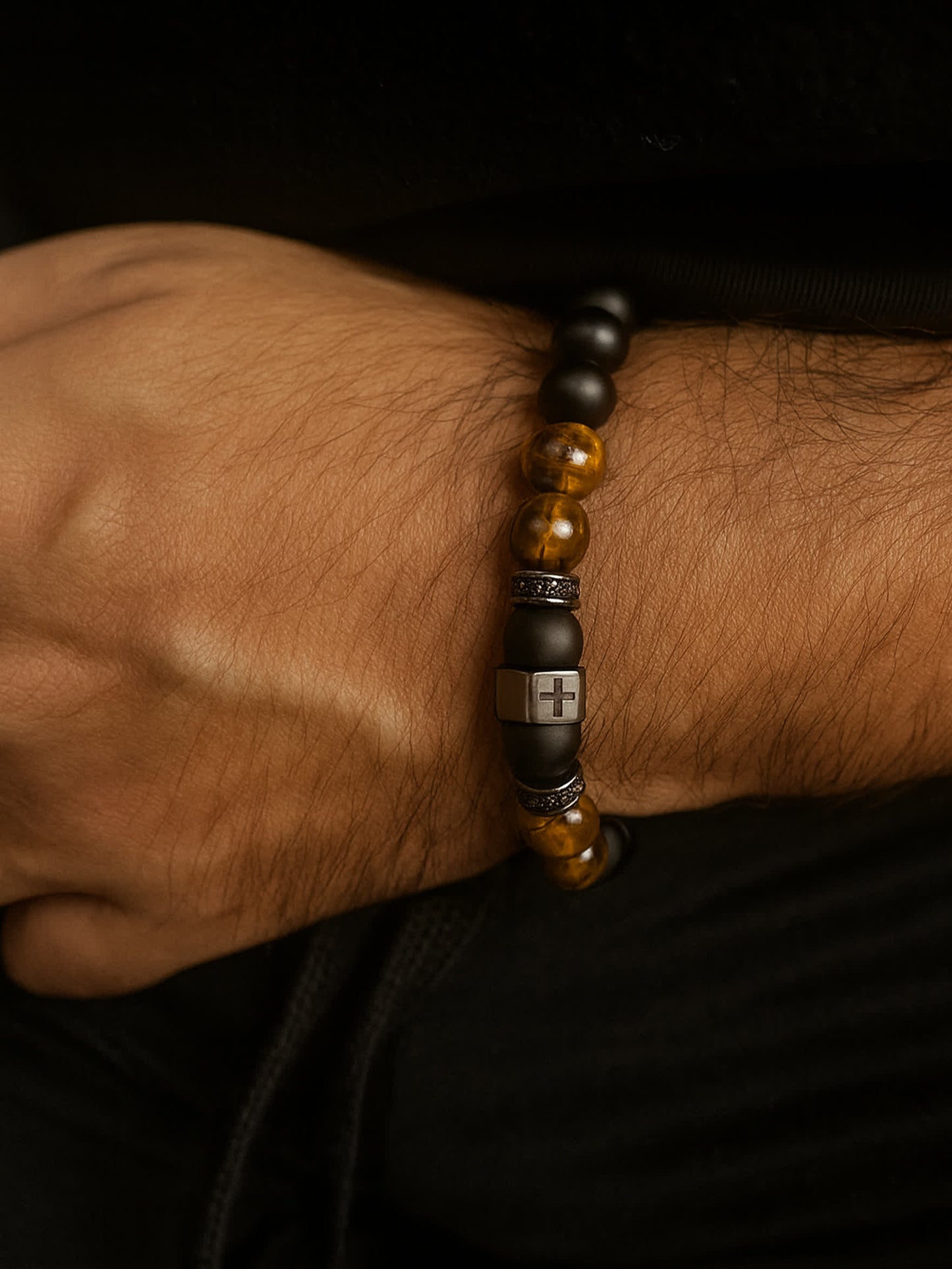Lifestyle image of the Lion's Peace Men's Religious Bracelet worn on a man's wrist, showing the stretch fit and centered cross detail in a natural everyday setting.