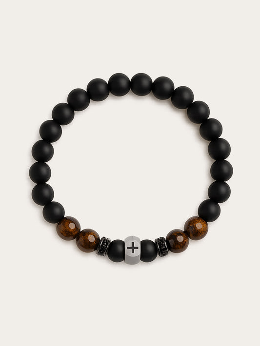 Front-facing studio photo of the Lion's Peace Men's Religious Bracelet made of black obsidian and tiger’s eye beads with stainless steel cross charm, displayed on a clean cream background.