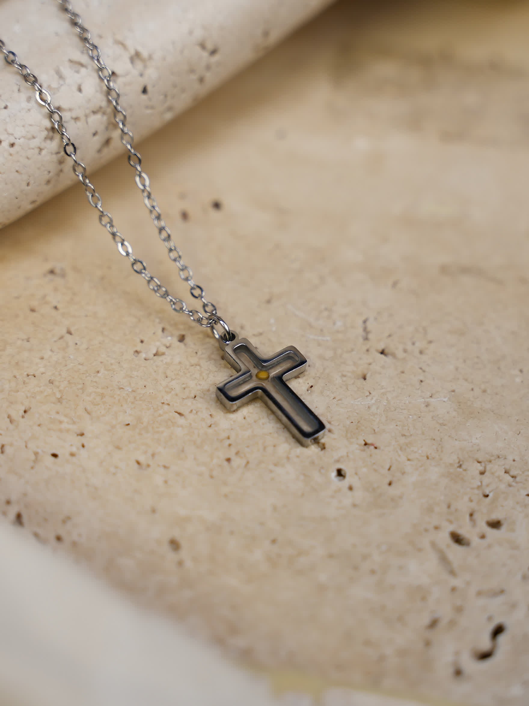 Necklace displayed on travertine slab
Faith of a mustard seed cross necklace placed on natural travertine stone with chain draped