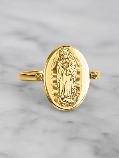 Close-up of the Our Lady ring on a marble surface, highlighting the detailed Virgin Mary engraving