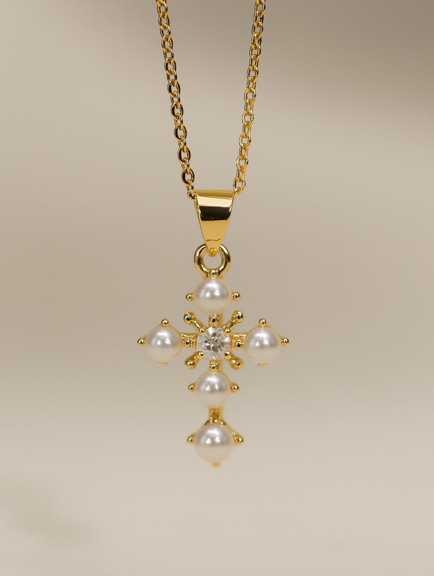 Delicate gold cross necklace with white pearls and flower-inspired design