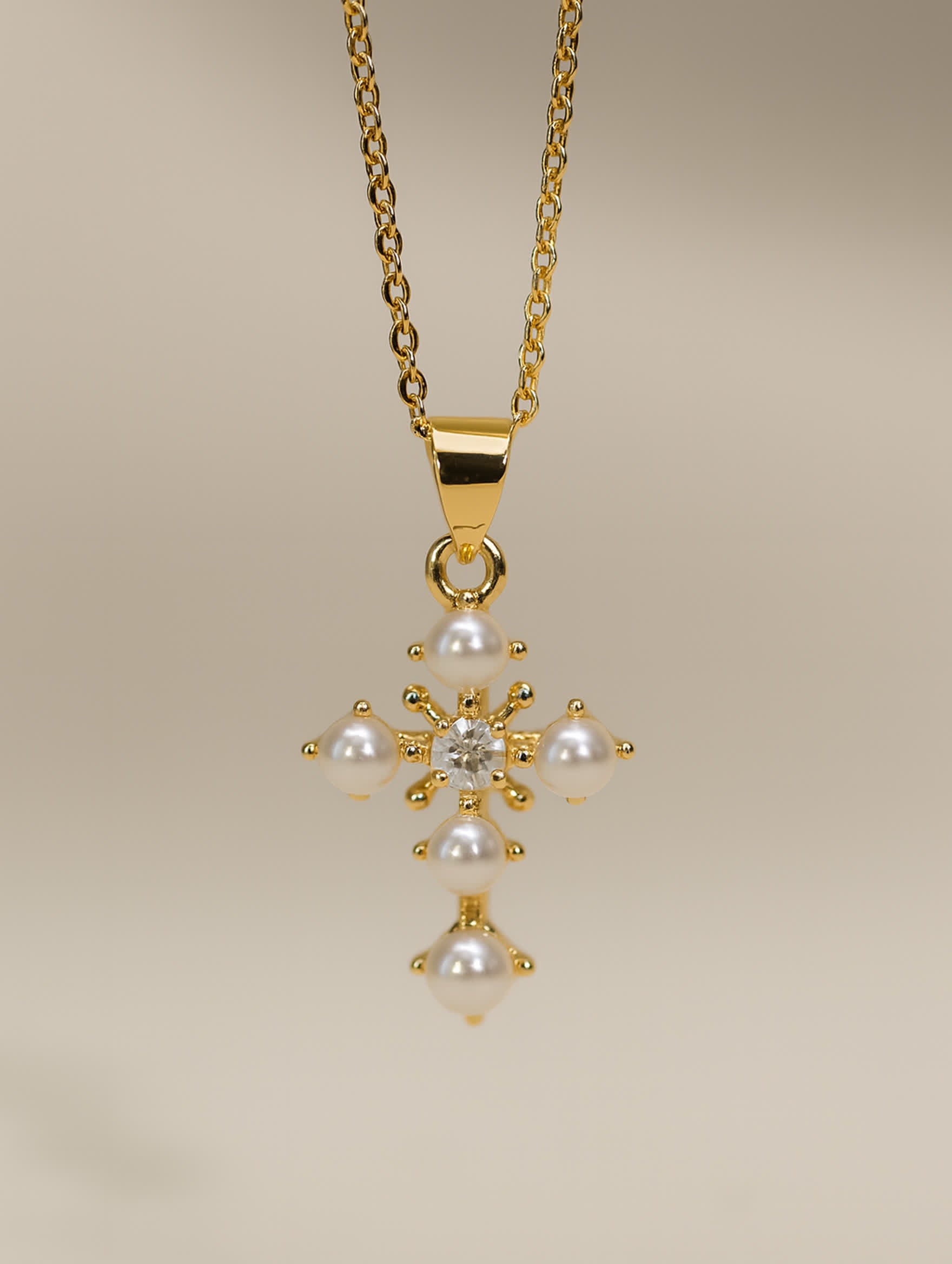 Delicate gold cross necklace with white pearls and flower-inspired design