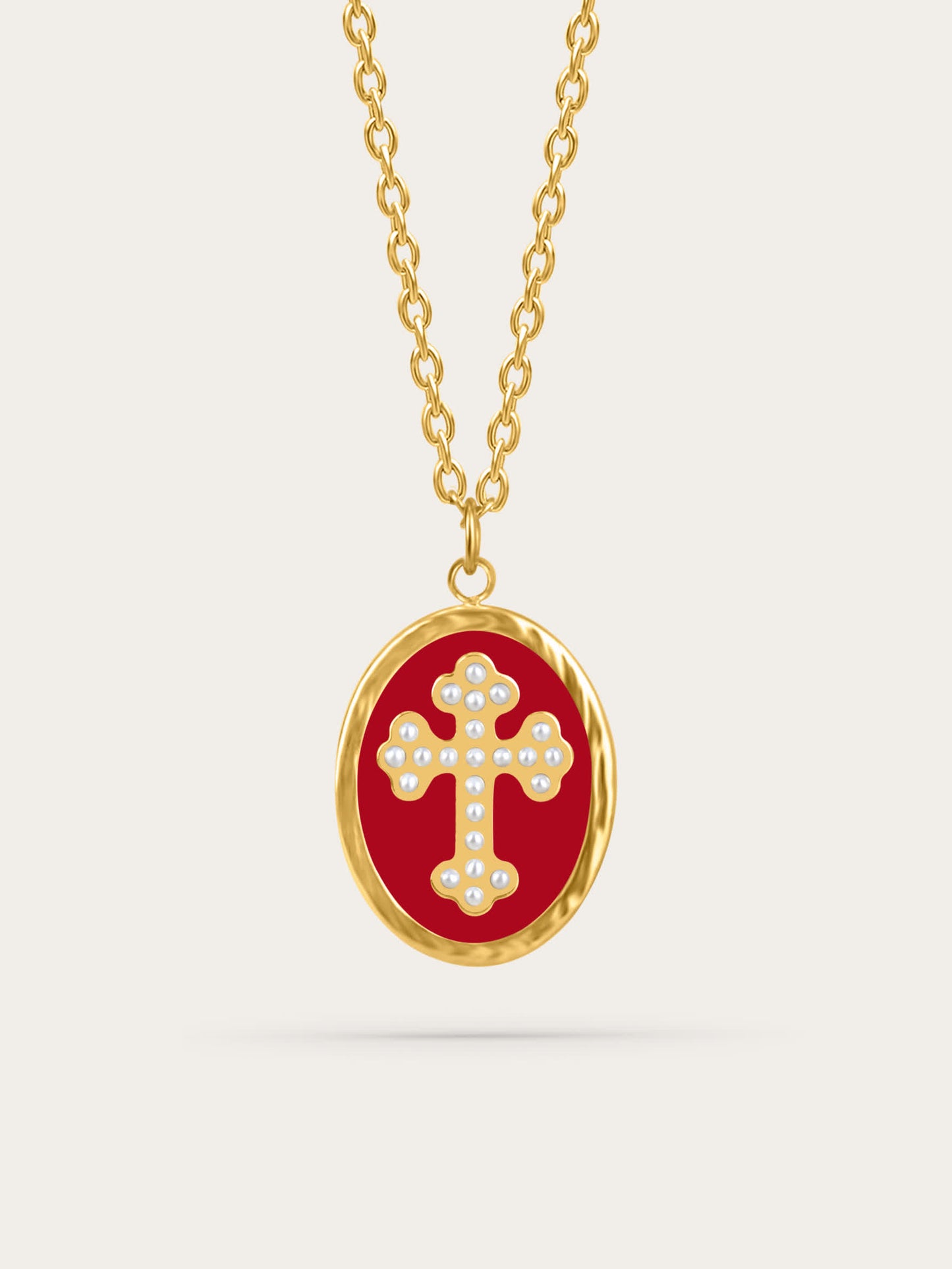 Crimson enamel cross pendant with pearl-accented gold cross on neutral background