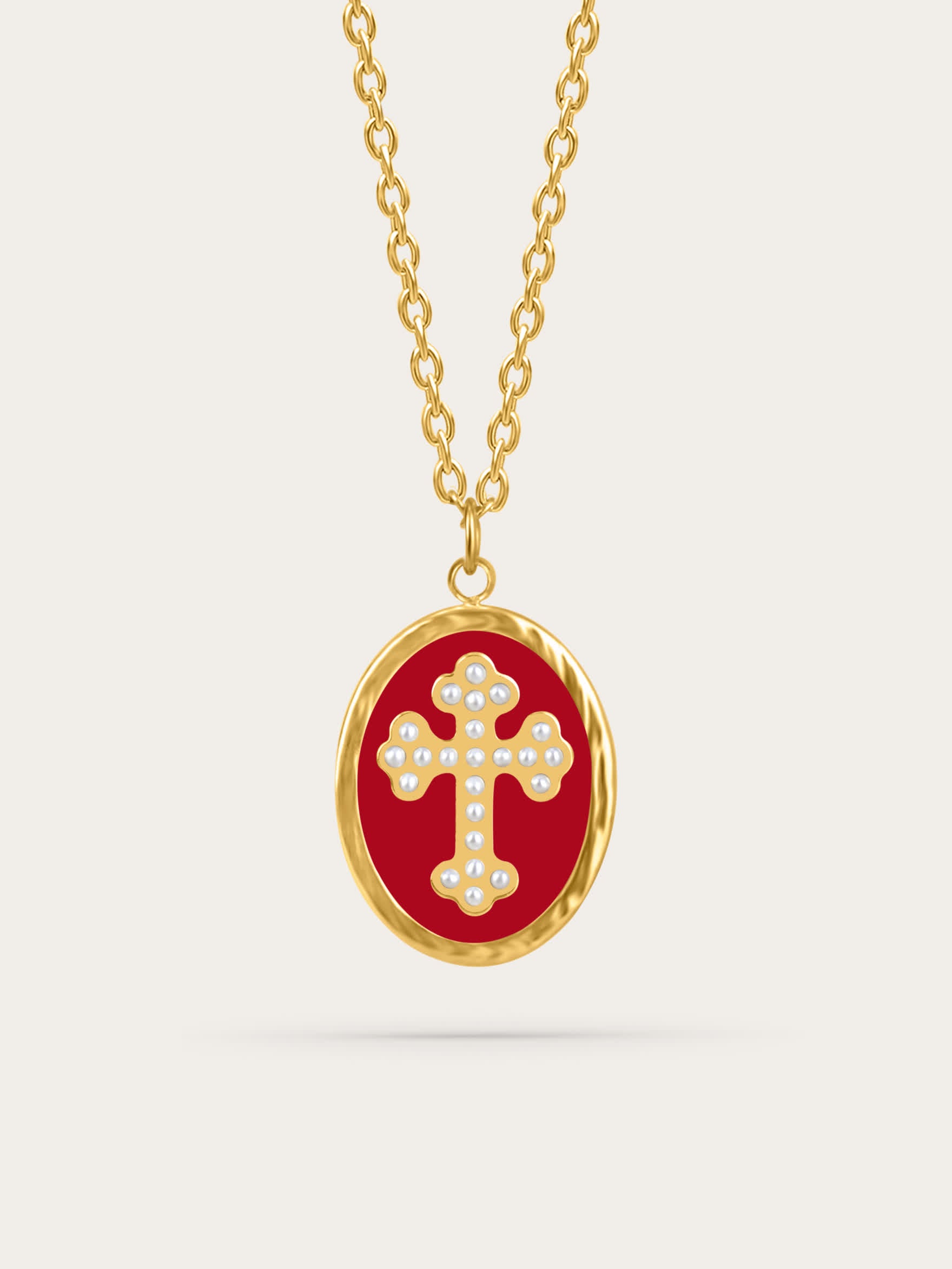 Crimson enamel cross pendant with pearl-accented gold cross on neutral background
