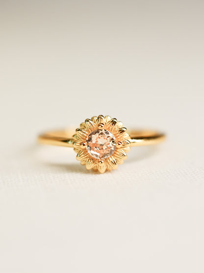 Front-facing image of the Shine Forth Sunflower Gold Ring with a round yellow zircon center and gold petal detailing on a neutral background