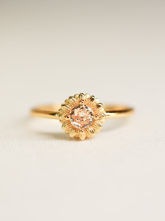 Front-facing image of the Shine Forth Sunflower Gold Ring with a round yellow zircon center and gold petal detailing on a neutral background