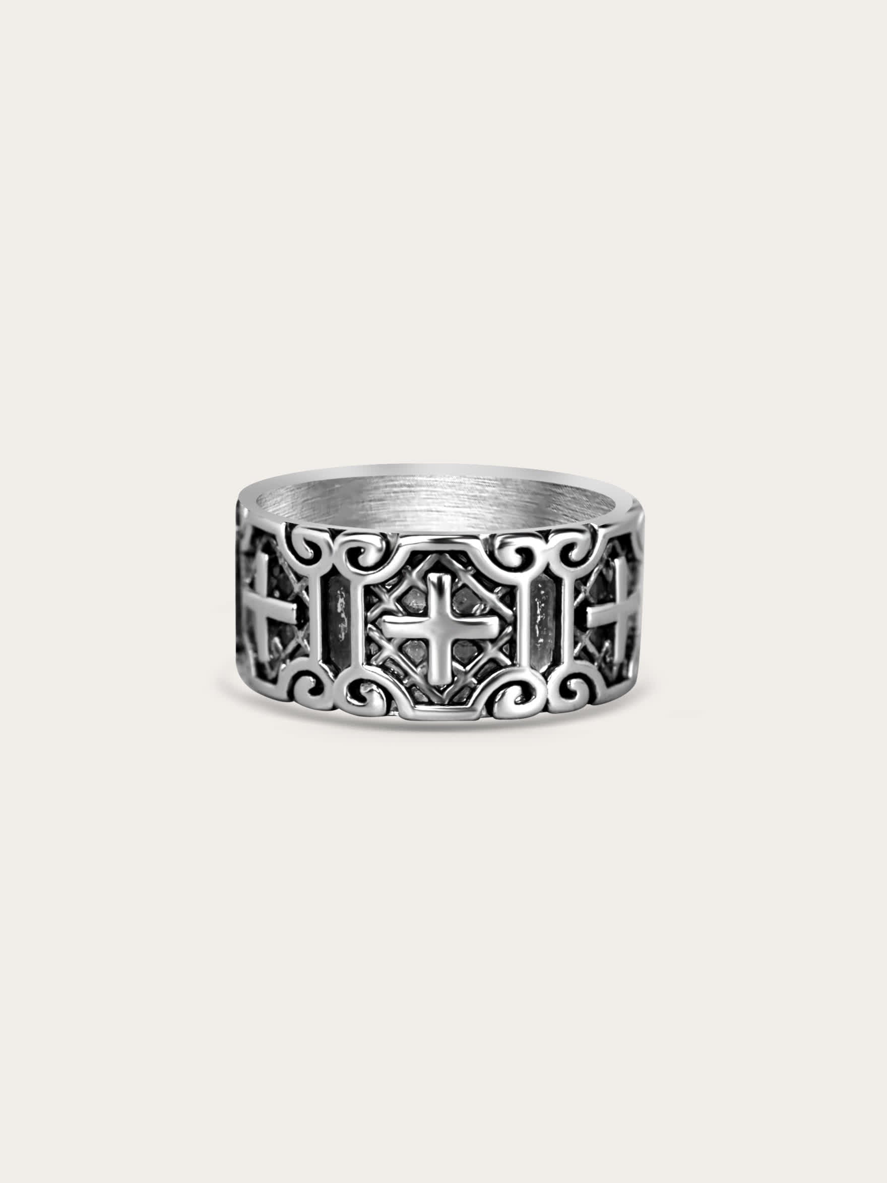Wide titanium steel cross ring with carved armor pattern on cream background