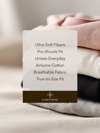Stack of folded clothes with Lumencross label detailing fabric properties. Christian apparel brand