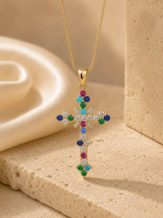 Gold cross necklace with colorful gemstones on a beige background