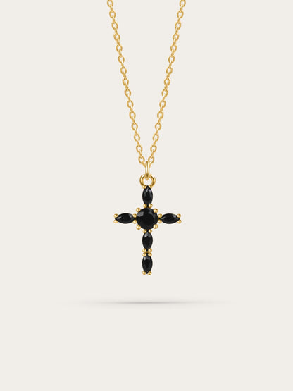 Studio photo of a black zircon marquise gold cross necklace on white background