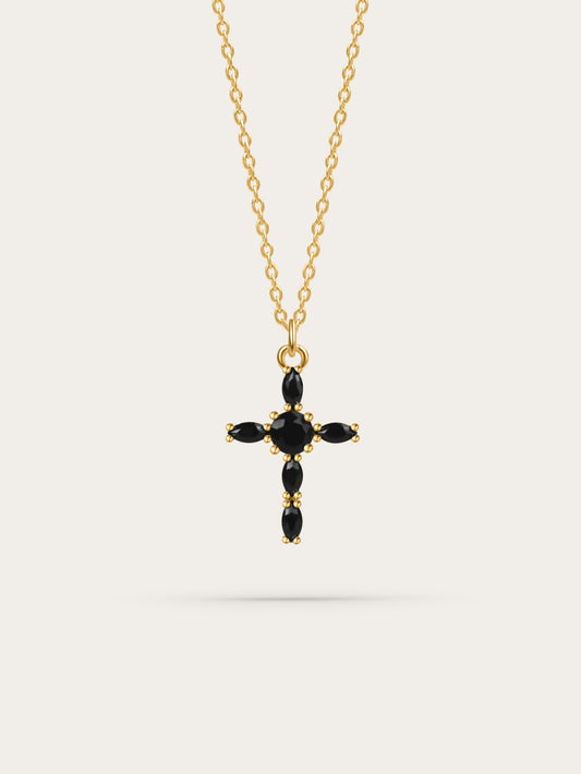 Studio photo of a black zircon marquise gold cross necklace on white background