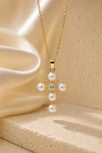 Gold necklace with a pearl pendant on a beige fabric background