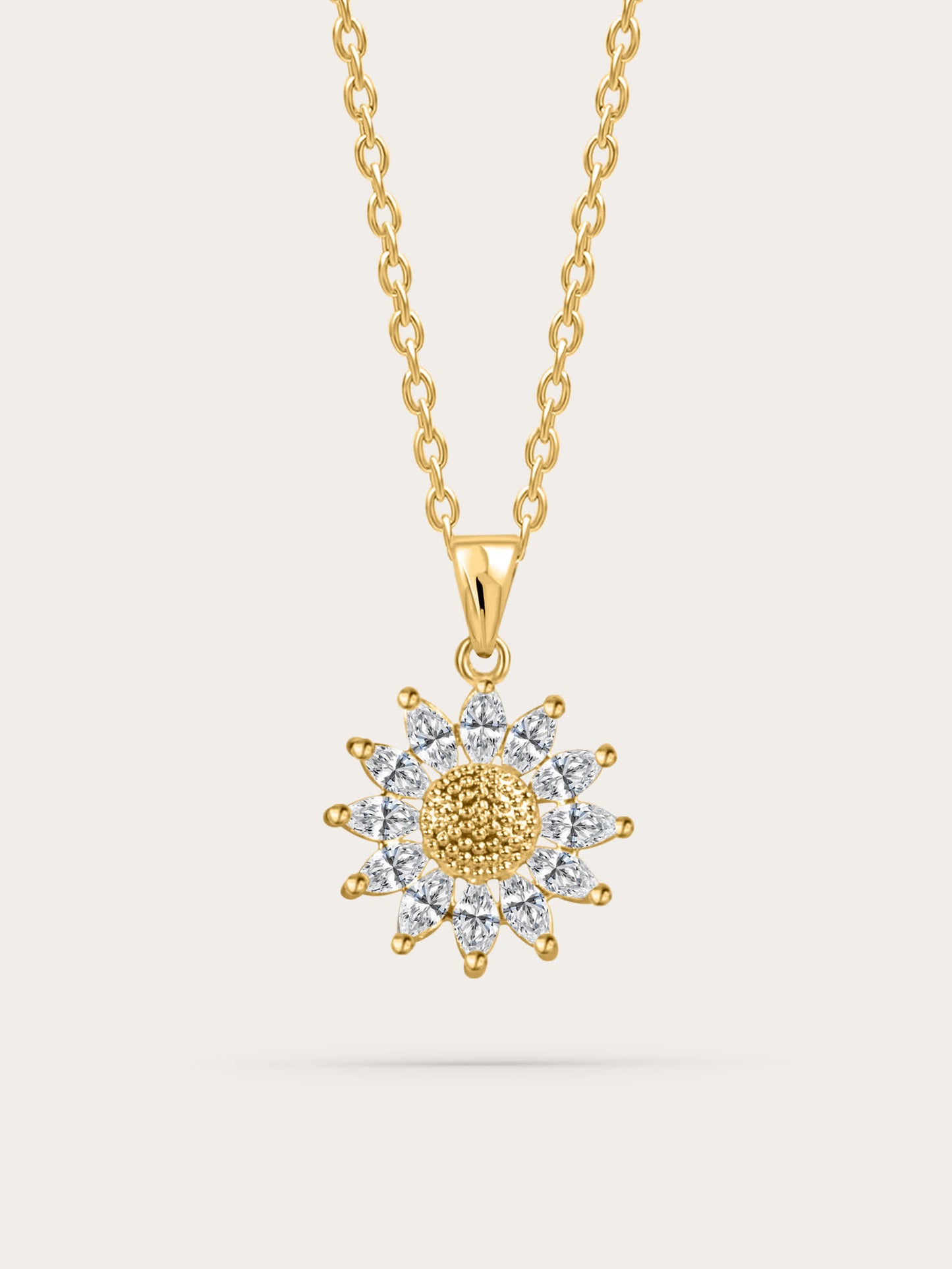 Gold sunflower-shaped pendant necklace with zircon petals, displayed on a cream background