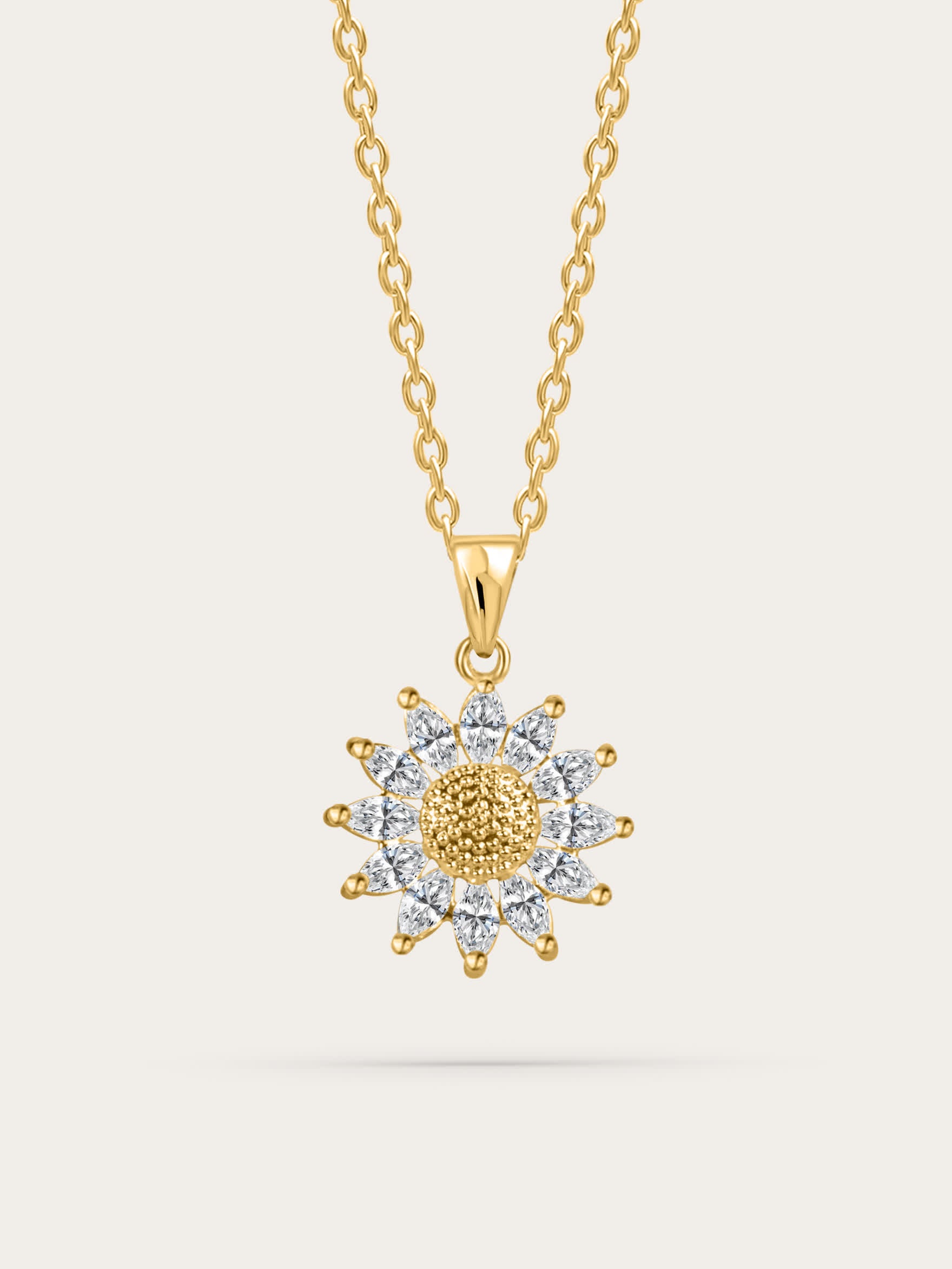 Gold sunflower-shaped pendant necklace with zircon petals, displayed on a cream background